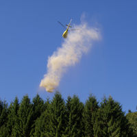 Ein Hubschrauber wirft gemahlenen Kalkstein über Waldflächen des Ortenaukreises ab.