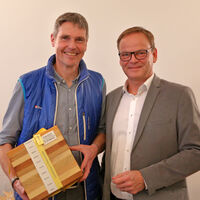 Landrat Frank Scherer (r.) berreichte Holger Schtz, Dezernent fr den Lndlichen Raum und Leiter des Amts fr Waldwirtschaft, zum Abschied einen Holzwrfel